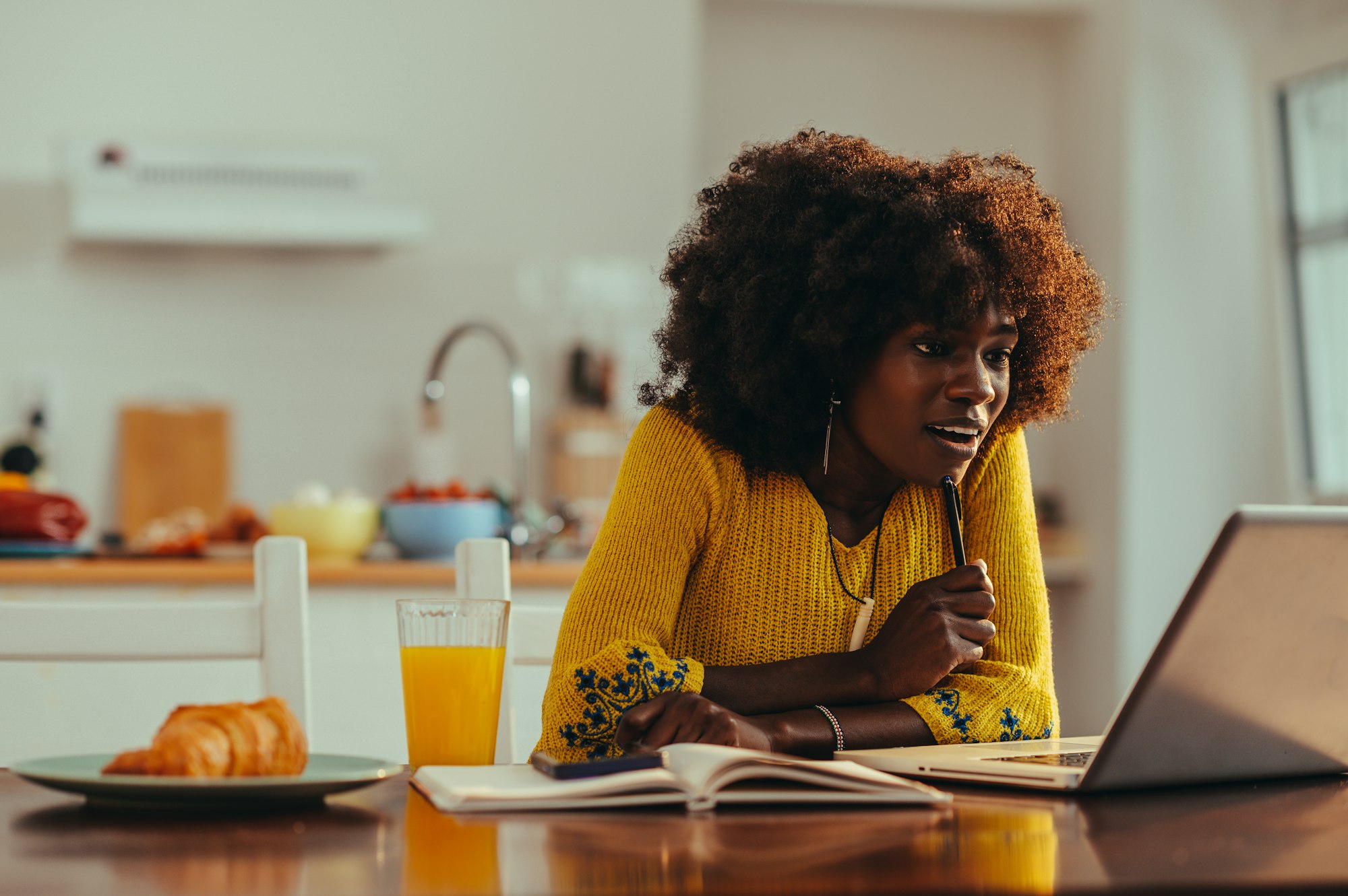 A focused african american female adult student is following an online lecture.